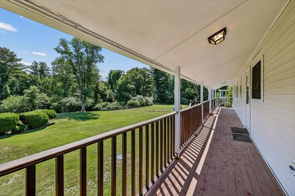 Spacious porch offers picturesque views of lush greenery, perfect for relaxing or entertaining.