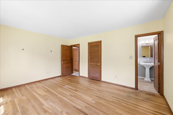 Bright, spacious room with warm wood accents, offering versatile layout and easy access to adjacent areas.