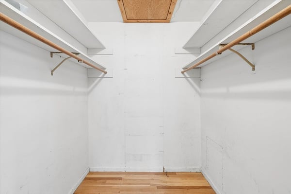 Spacious walk-in closet features ample hanging space, offering potential for organized storage solutions.