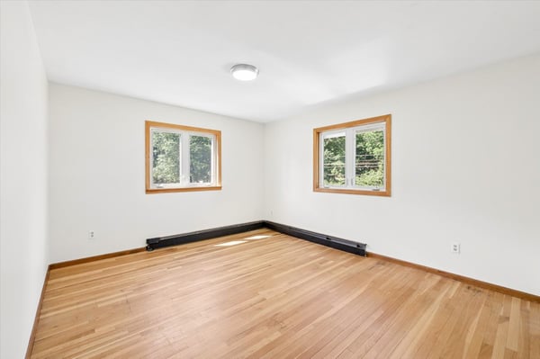 Spacious room with abundant natural light and hardwood flooring, perfect for customizing your ideal living space.