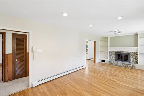 Spacious living area featuring a cozy fireplace and built-in shelves, perfect for personalized decor.