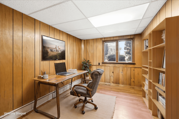 Bright and inviting home office featuring warm wooden walls and ample natural light for productivity.