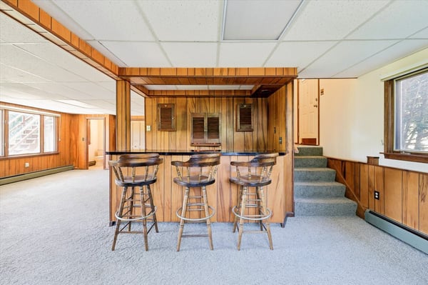 Spacious lower level featuring a cozy bar area and ample natural light throughout.