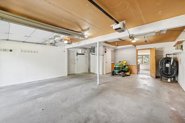 Spacious garage with ample room for storage and vehicles, featuring bright overhead lighting and easy access.