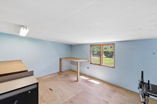 Spacious room with ample natural light, featuring a convenient workspace and easy access to the outdoors.