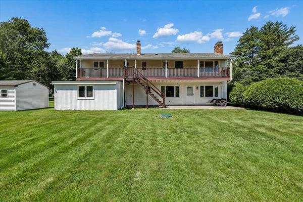 Spacious two-story home with a vast backyard and multiple outdoor areas for relaxation and entertainment.