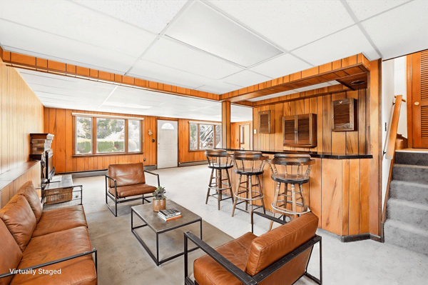 Spacious living area features a bar and ample natural light, perfect for entertaining or relaxing.