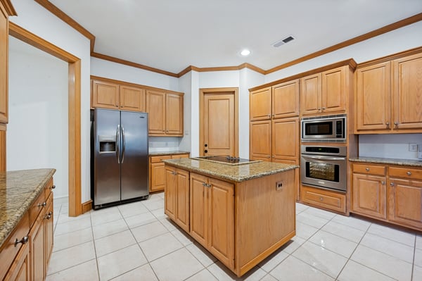 Spacious kitchen featuring abundant cabinetry, granite countertops, and modern stainless steel appliances for an inviting cooking experience.