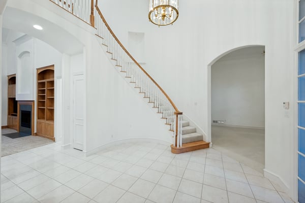 This spacious entryway features a grand staircase and abundant natural light, perfect for welcoming guests.