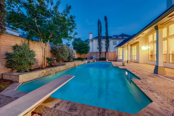 Discover a refreshing outdoor oasis featuring a spacious pool surrounded by lush landscaping, perfect for entertaining.