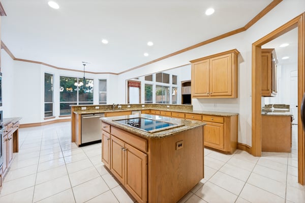 Spacious kitchen featuring granite countertops, a large island, and abundant natural light from panoramic windows.