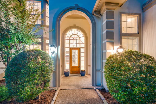 Welcoming entryway featuring grand arches and vibrant landscaping, perfect for making a lasting first impression.