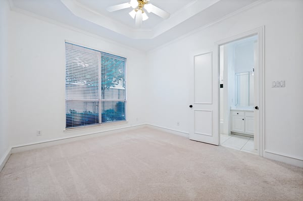 Bright and spacious bedroom featuring a ceiling fan and direct access to a connected bathroom.