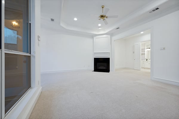 Spacious living area featuring a cozy fireplace and natural light from large windows.