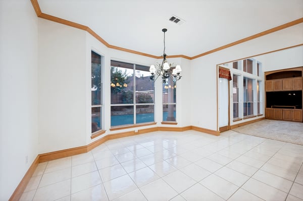 Spacious dining area with large windows, offering abundant natural light and views of the backyard.
