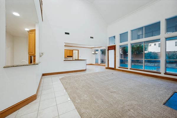 Spacious living area with tall ceilings and abundant natural light, ideal for comfortable gatherings and entertaining.