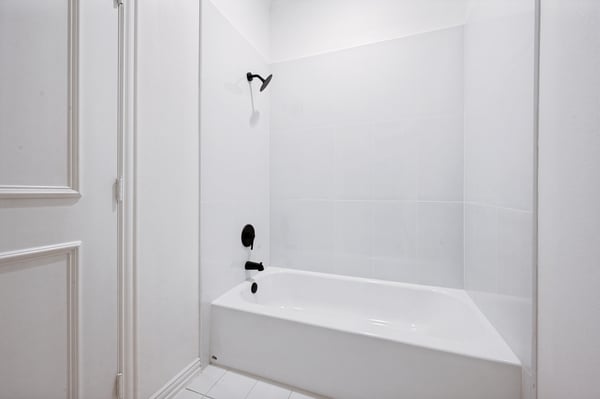 Modern bathroom featuring a clean design with a spacious tub and sleek fixtures, perfect for relaxation.