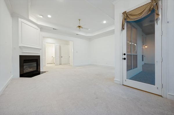 Spacious primary bedroom featuring a cozy fireplace and seamless access to a private sitting area.