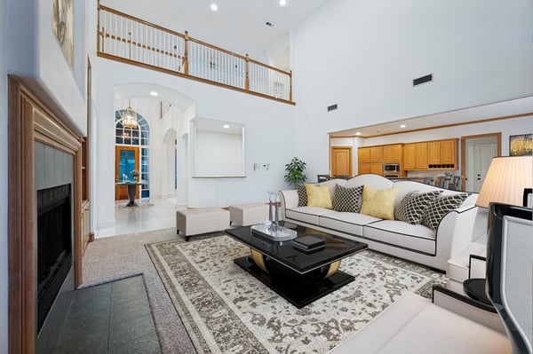 Spacious living room featuring high ceilings, natural light, and modern furnishings, perfect for entertaining or relaxation.