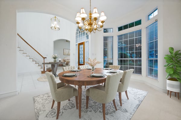 Bright and inviting dining area, featuring large windows, a beautiful chandelier, and a welcoming atmosphere.