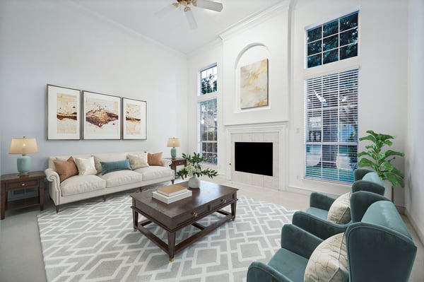 Bright, spacious living room featuring large windows, modern furnishings, and a cozy fireplace for gatherings.