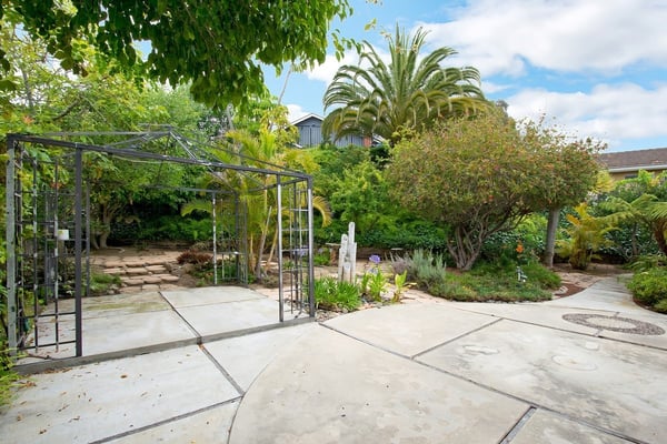 Discover a lush, tranquil garden oasis featuring decorative pathways and vibrant landscaping, perfect for outdoor relaxation.