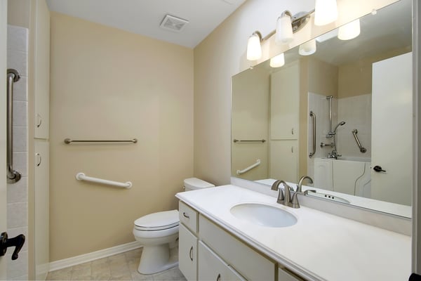 Spacious and well-lit bathroom featuring modern fixtures and easy-access shower for comfort and convenience.