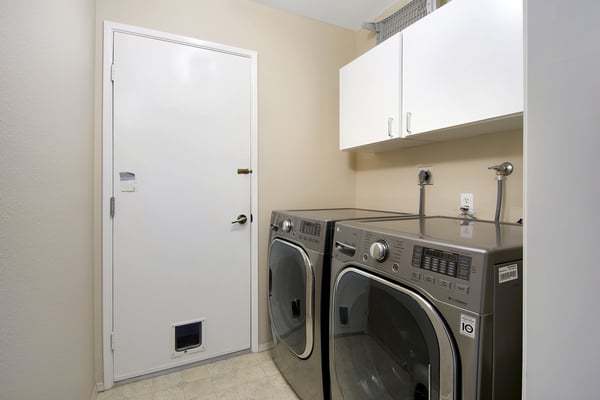 Bright and spacious laundry room featuring modern appliances and ample storage for convenient organization.