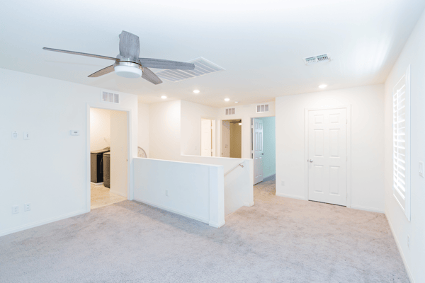 Bright, open living space with a modern ceiling fan, featuring versatile layouts and updated finishes throughout.