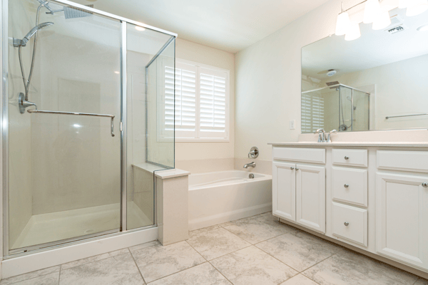 This bright bathroom features a spacious shower, separate tub, and ample storage in a modern design.