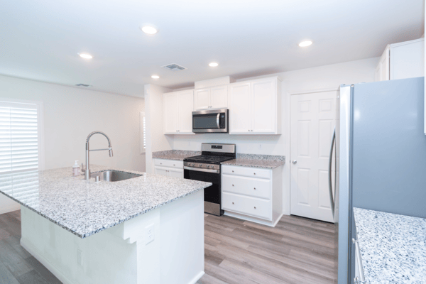 Modern kitchen featuring sleek countertops, stainless steel appliances, and ample storage in a bright, open layout.