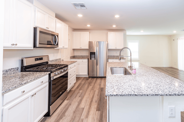 This modern kitchen features granite countertops, stainless steel appliances, and ample storage space for culinary enthusiasts.