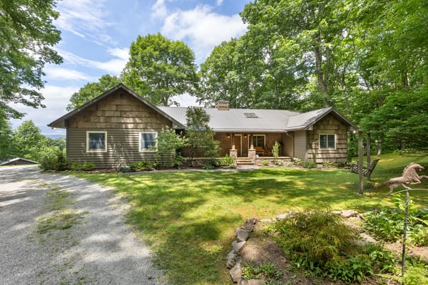 Spacious, wood-clad home surrounded by lush greenery, offering a tranquil retreat with scenic views.