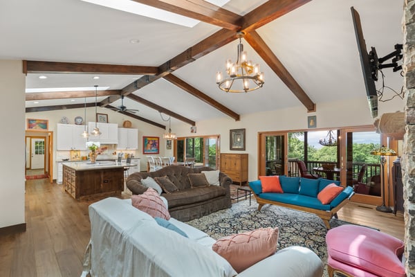Spacious open-plan living area featuring vaulted ceilings, modern kitchen, and gorgeous mountain views from the balcony.
