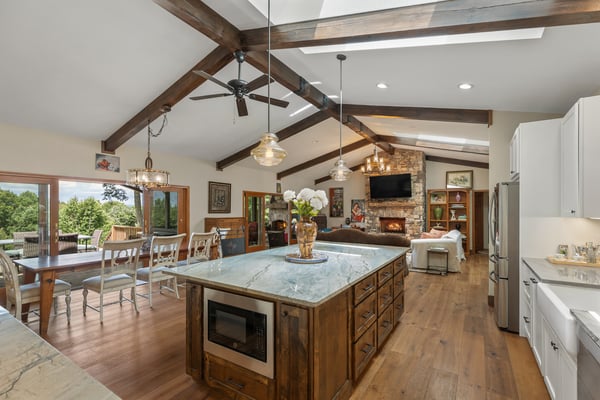 Bright and spacious kitchen featuring a large island, vaulted ceilings, and seamless outdoor access.
