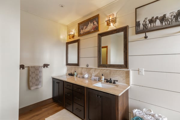 Spacious bathroom featuring dual vanities, modern fixtures, and unique artwork for a distinctive touch.