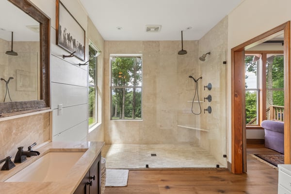 Spacious bathroom featuring a large walk-in shower and ample natural light, perfect for relaxation.