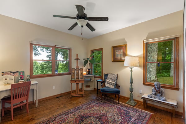 Bright and inviting space featuring large windows, a cozy reading nook, and natural wood accents.