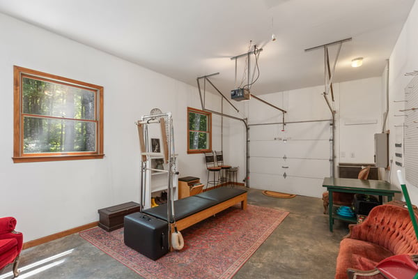 Spacious garage featuring workout equipment, natural light, and ample storage for your recreational needs.