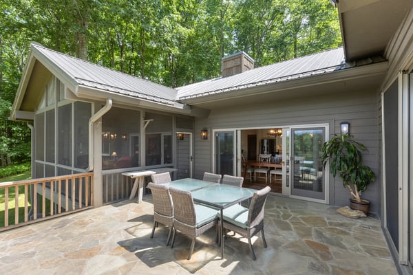 Spacious outdoor patio ideal for entertaining, surrounded by lush greenery and natural light.
