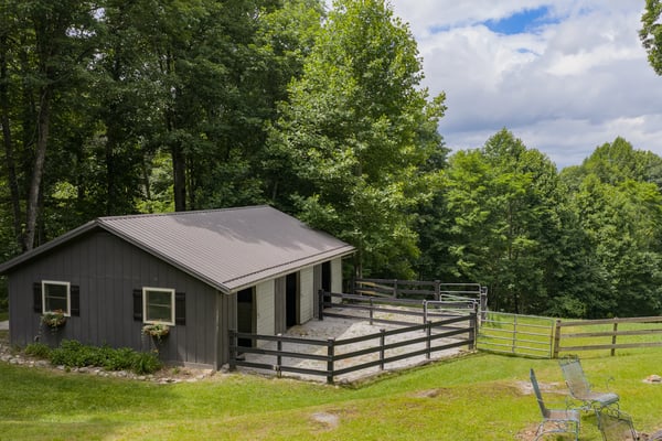 This rustic property features a spacious barn, surrounded by lush greenery and scenic landscapes.