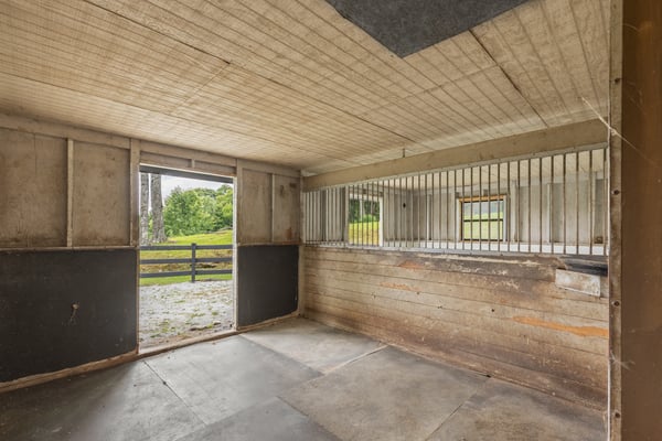 Spacious indoor area with large access doors, perfect for a variety of uses or livestock housing.