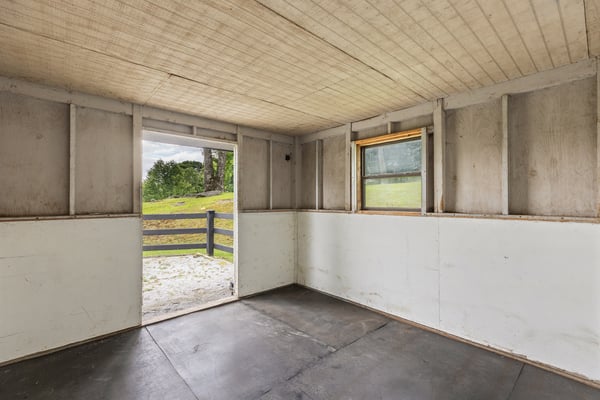 Spacious interior with potential for customization, featuring a door leading to scenic outdoor views.