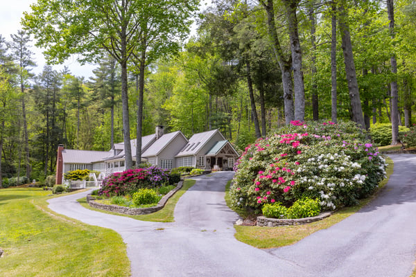 Nestled among lush greenery, this stunning property features expansive gardens and a winding driveway for added privacy.
