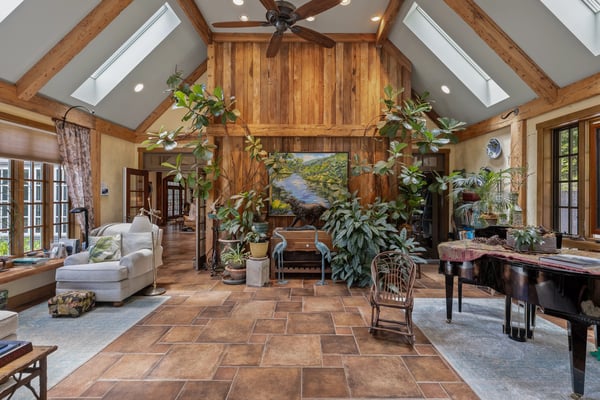 Spacious living area featuring natural light, high ceilings, and abundant greenery for a cozy atmosphere.