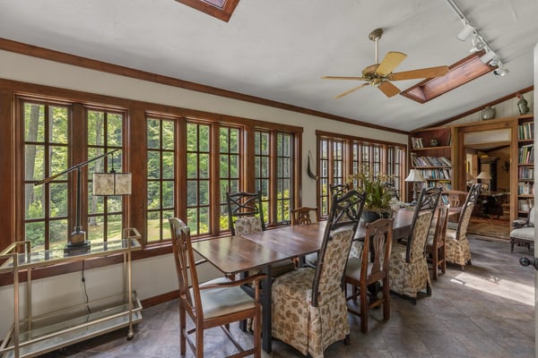 Bright sunroom with expansive windows, perfect for dining and enjoying garden views year-round.