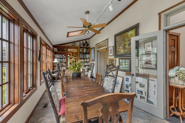 Bright and inviting dining area features ample natural light, a spacious table, and built-in bookshelves.