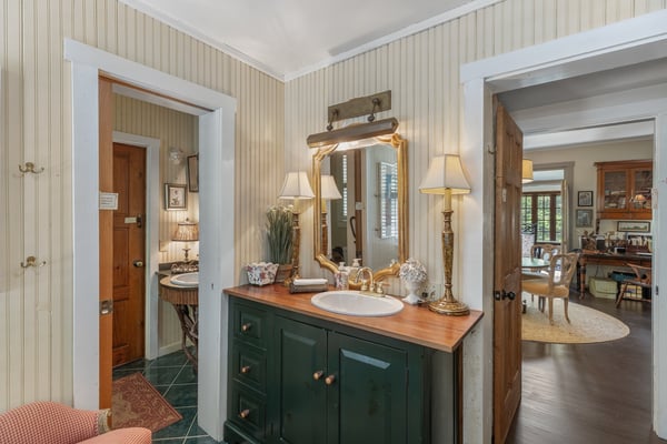 This inviting bathroom features a vintage sink and warm lighting, seamlessly connecting to adjoining living spaces.