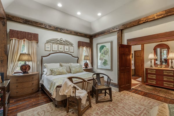 Bright and inviting bedroom featuring warm wood accents and an adjoining vanity area for convenience.