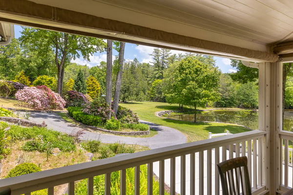 Enjoy picturesque views from the porch, featuring lush gardens and a tranquil pond in a private setting.